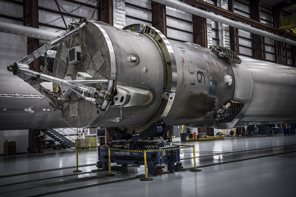 Rocket booster stage being prepared inside an aerospace manufacturing hangar