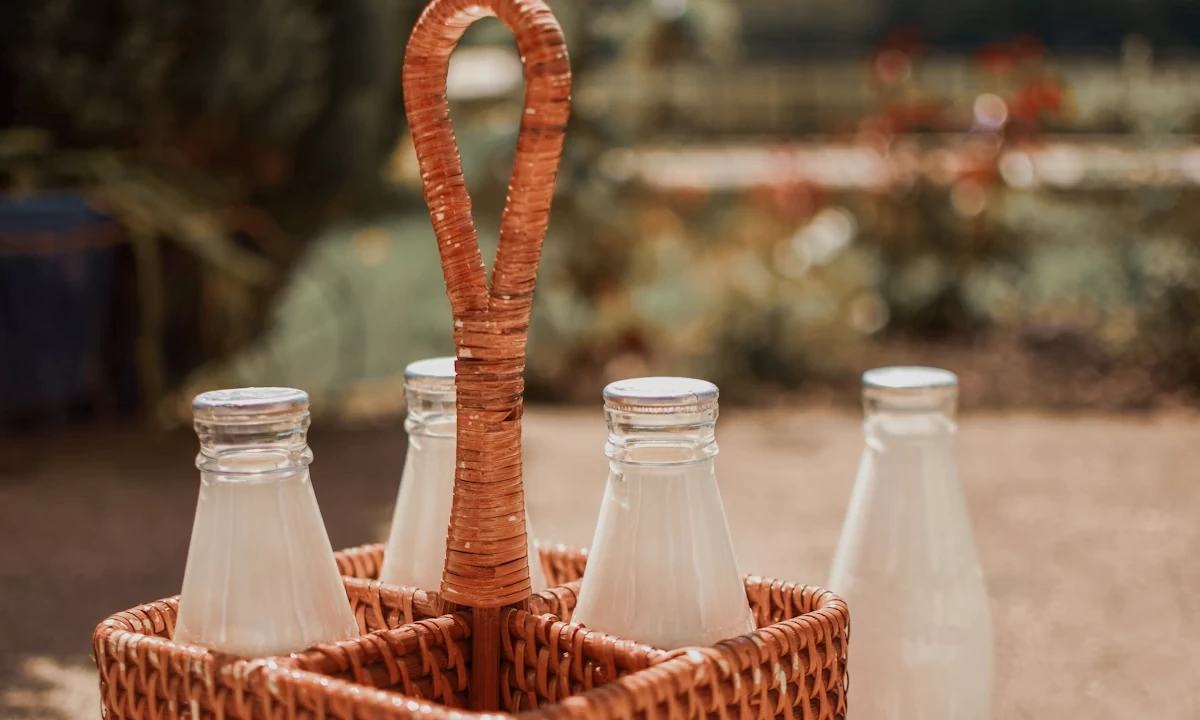 Glass milk bottles in a wooden crate representing a dairy brand