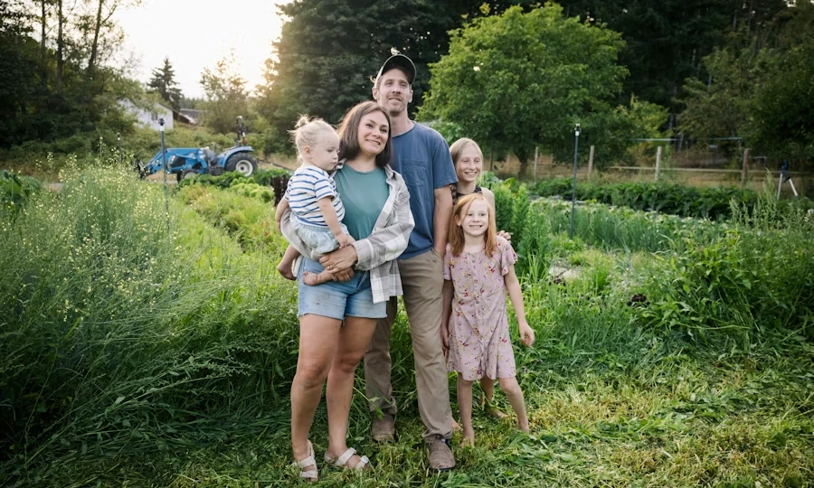 Family standing together in a green farm field with a tractor