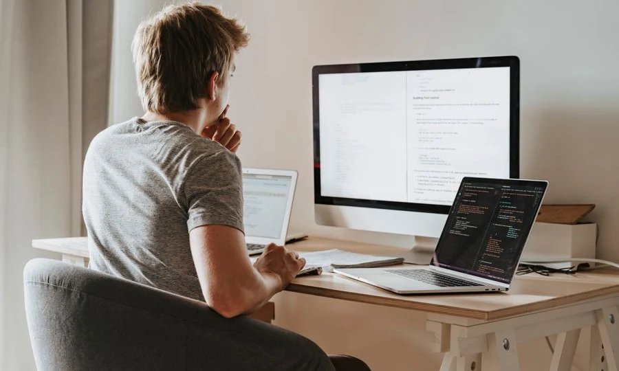 Machine learning engineer working across multiple computer screens