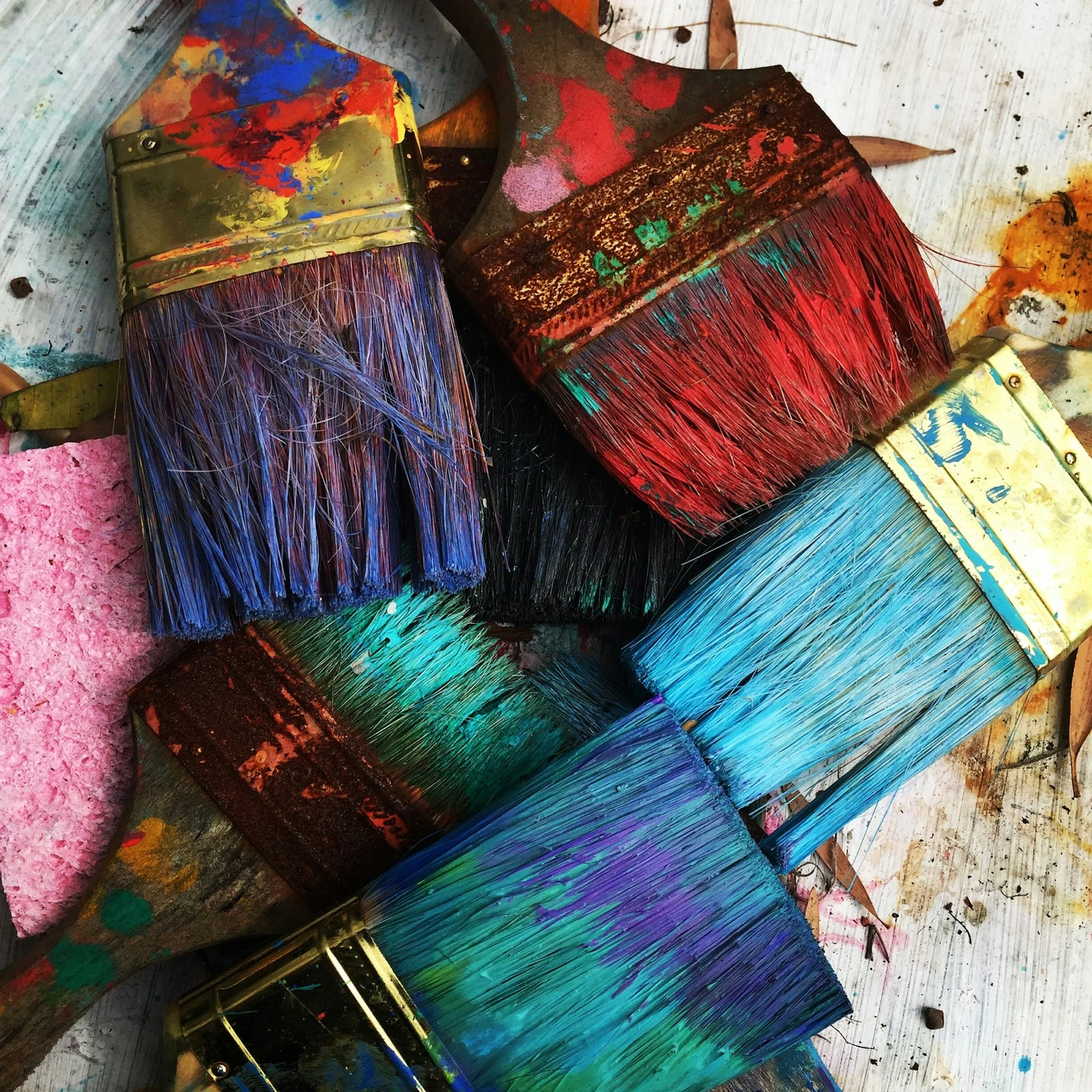 Used paintbrushes with vibrant paint in an artist studio workspace