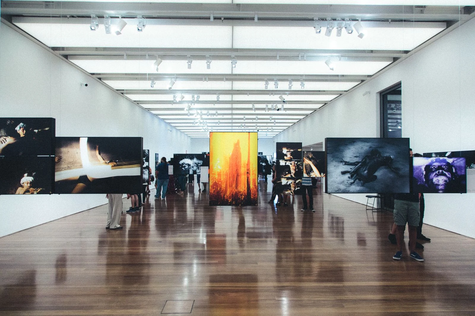 Visitors walking through a modern photography exhibition gallery hall
