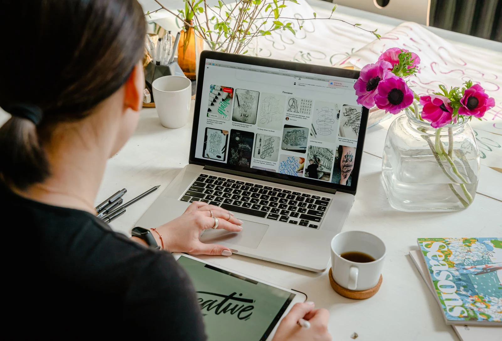 Digital designer creating graphic artwork on a laptop and drawing tablet