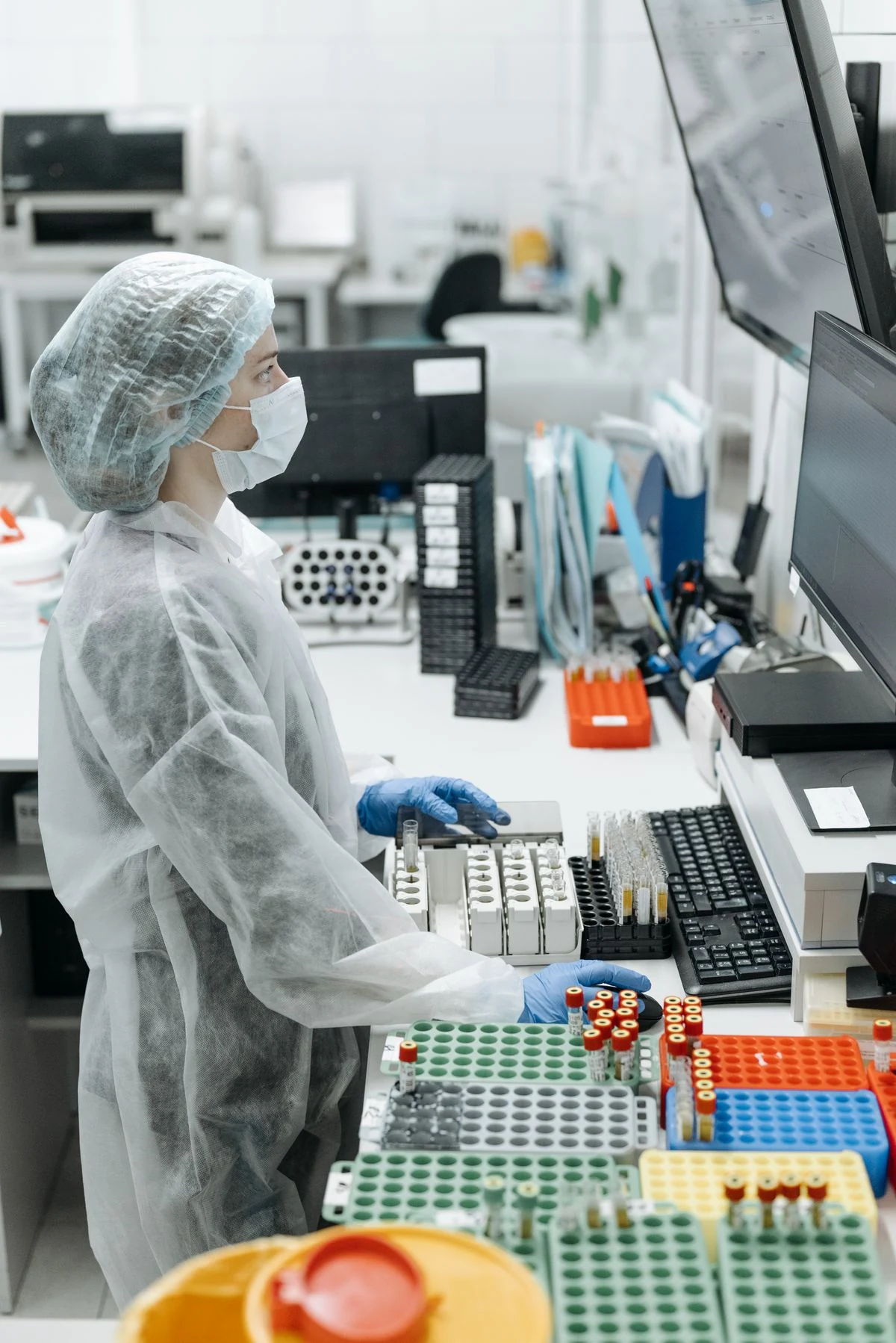 Scientist analyzing genomic data on lab computer monitors