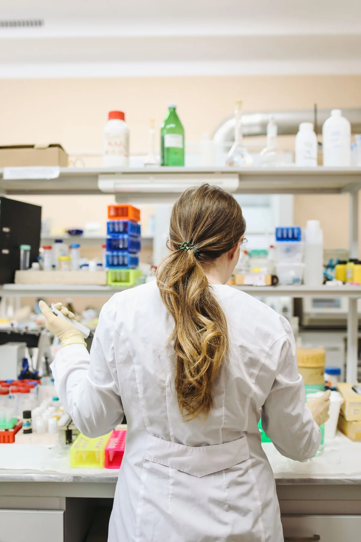 Scientist working at a fully stocked laboratory shelf