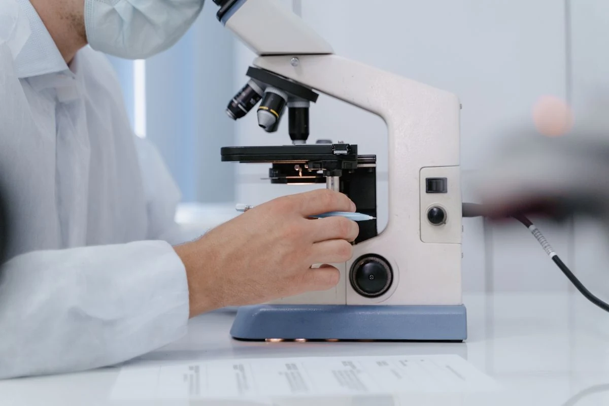 Scientist examining a sample under a microscope