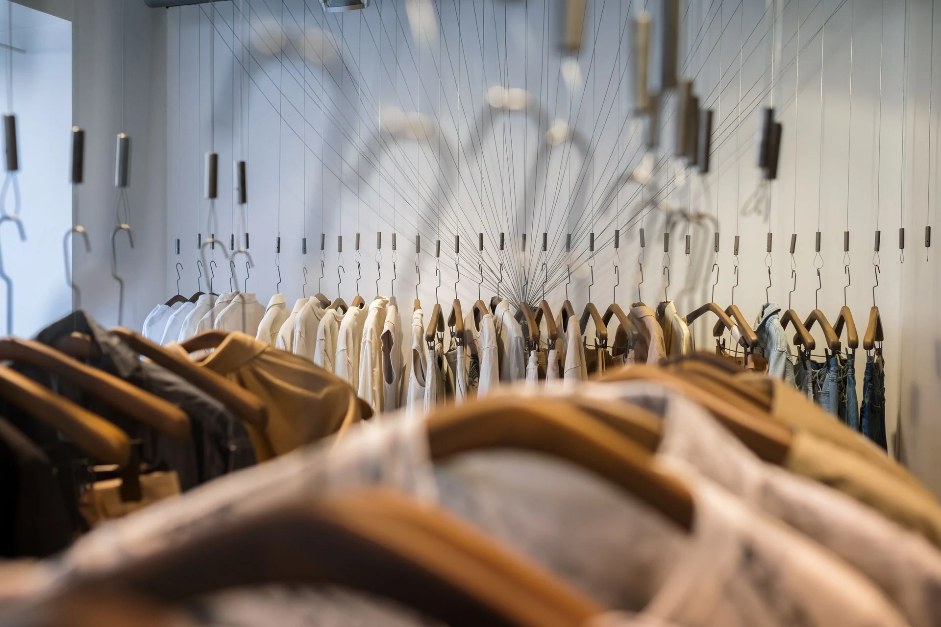 Artistic clothing rack with garments on wooden hangers
