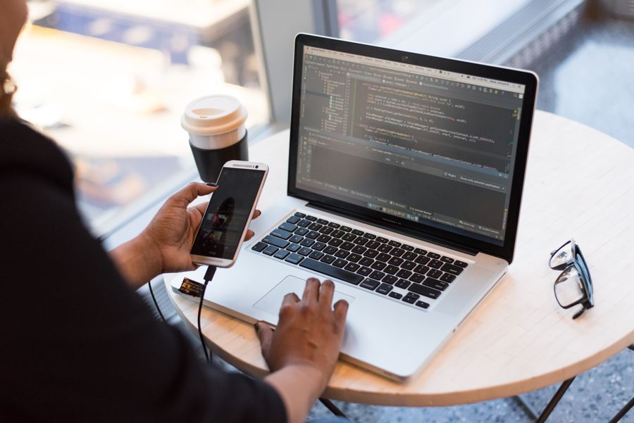 Analyst reviewing data on dual monitor coding setup