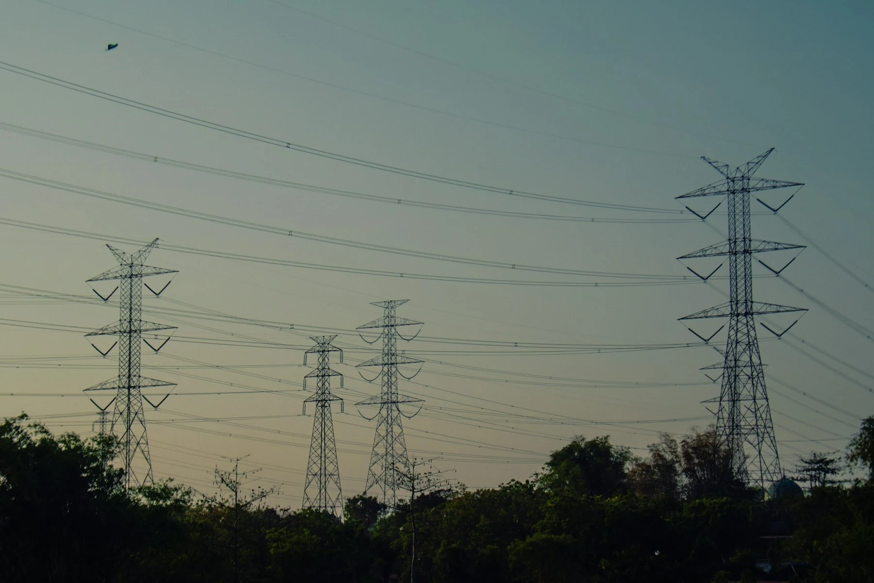 Power transmission towers and lines against a dusky sky