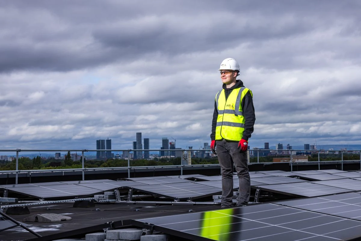 Engineer inspecting solar panels on a rooftop