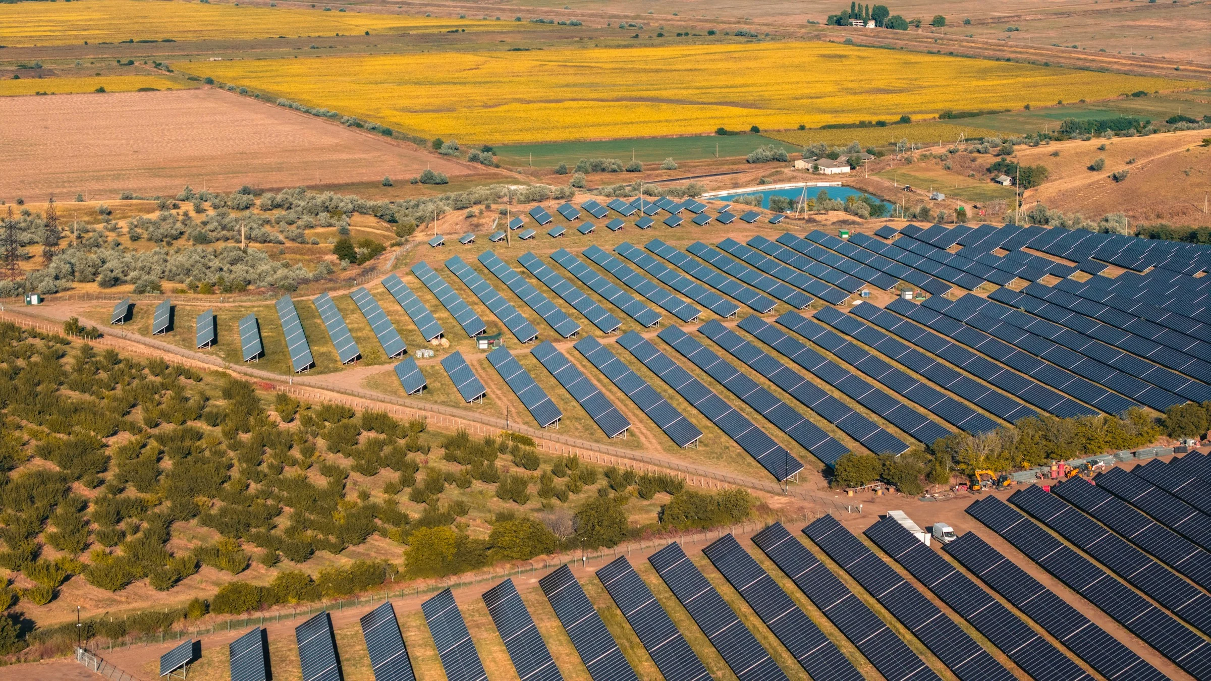 Aerial view of a solar panel farm on green rolling hills