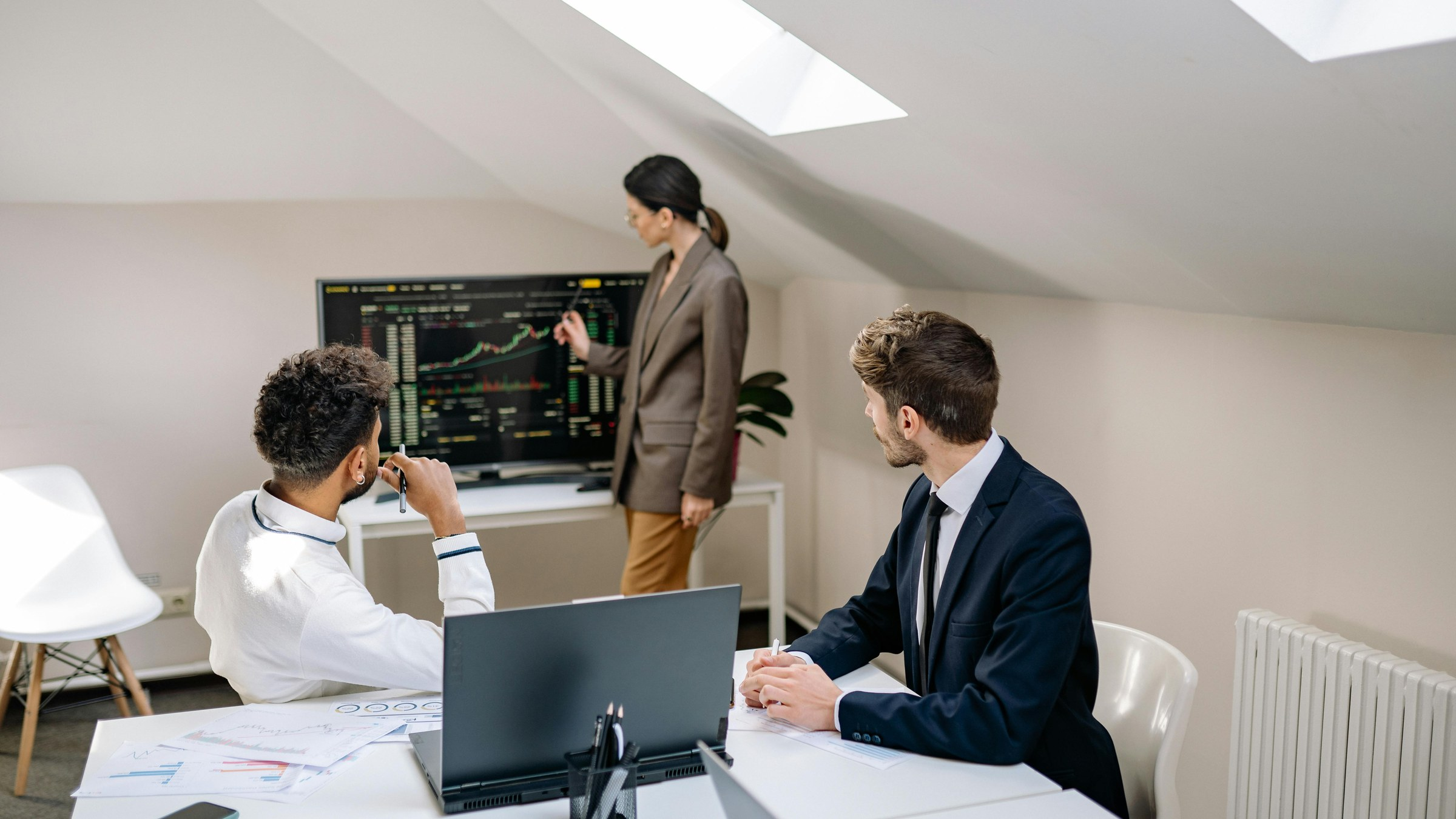 Professional finance office with advisors reviewing market data