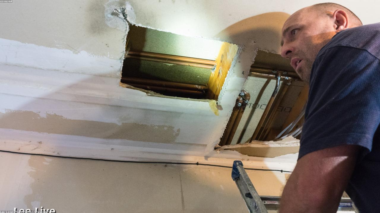 Professional plumber working on residential sink repair