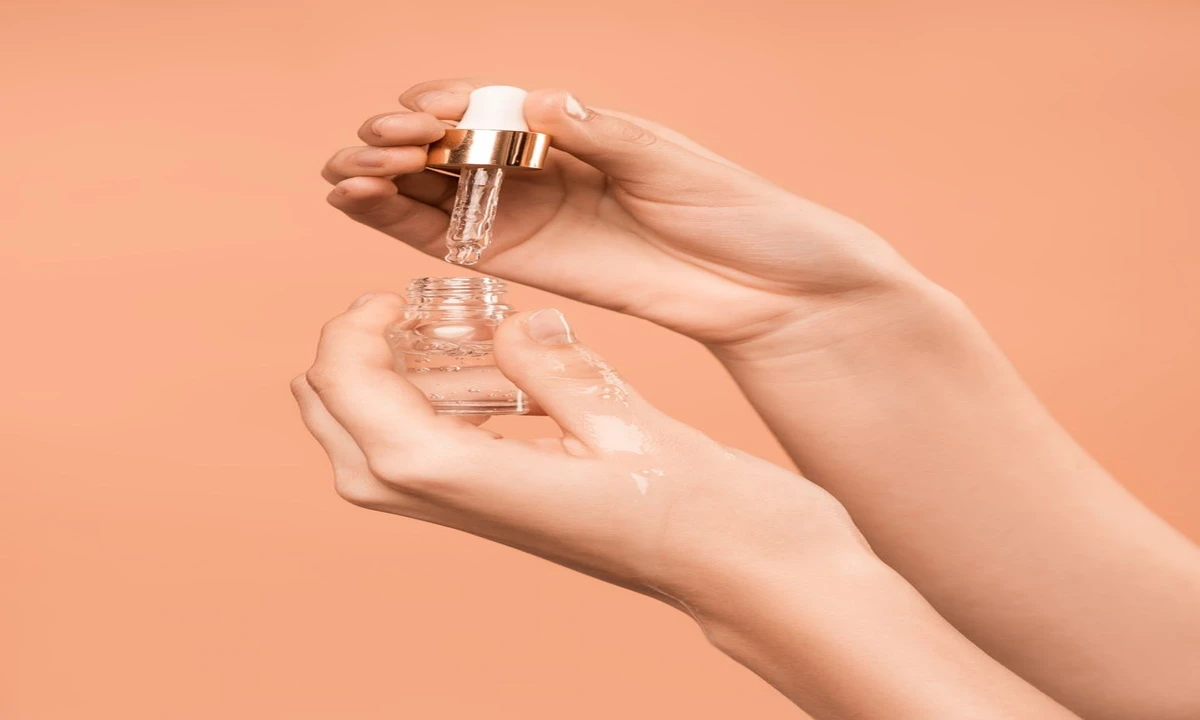 Person applying luxury skincare serum dropper as part of premium beauty routine