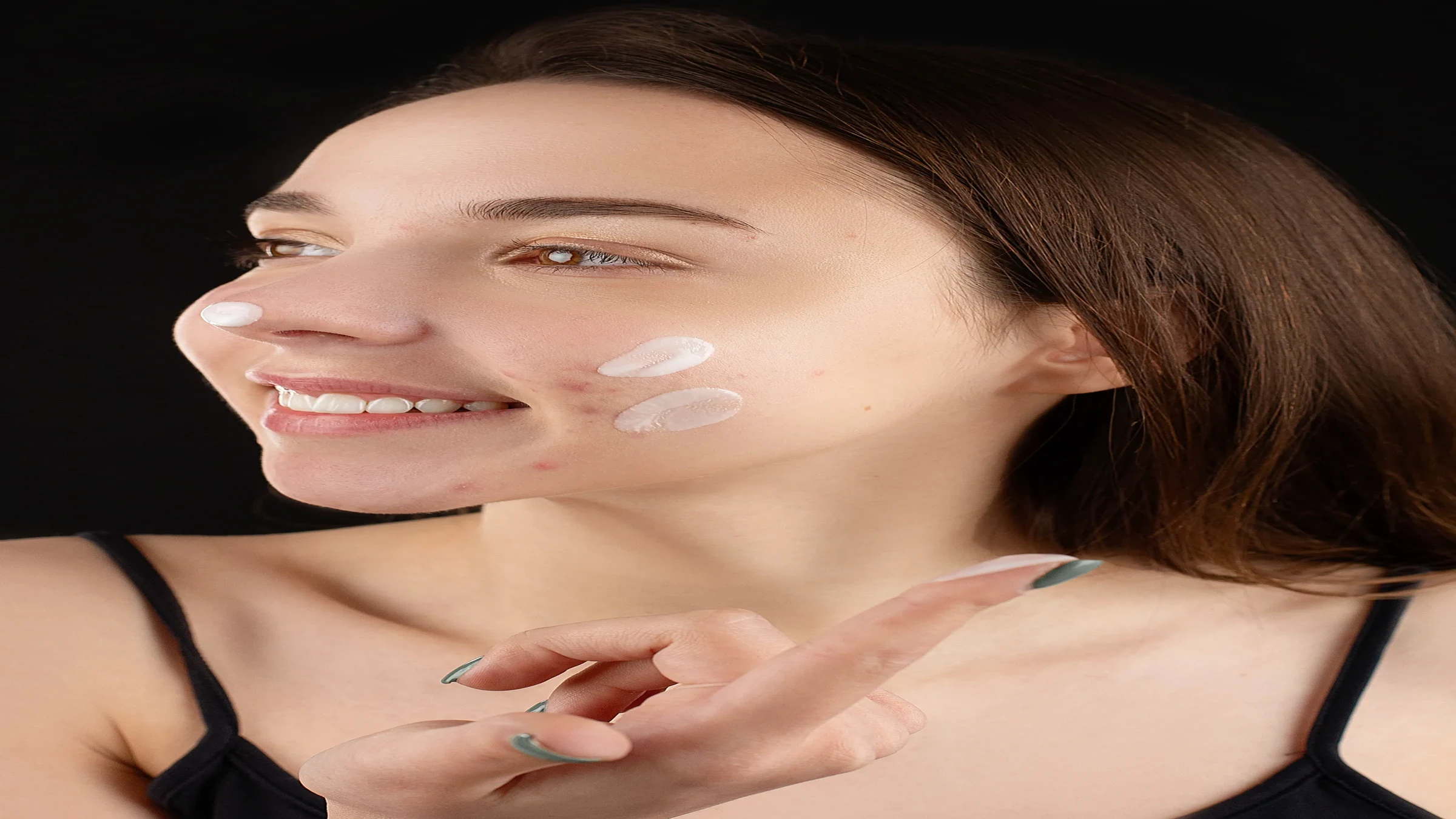 Woman applying skincare cream to her face as part of a daily beauty routine