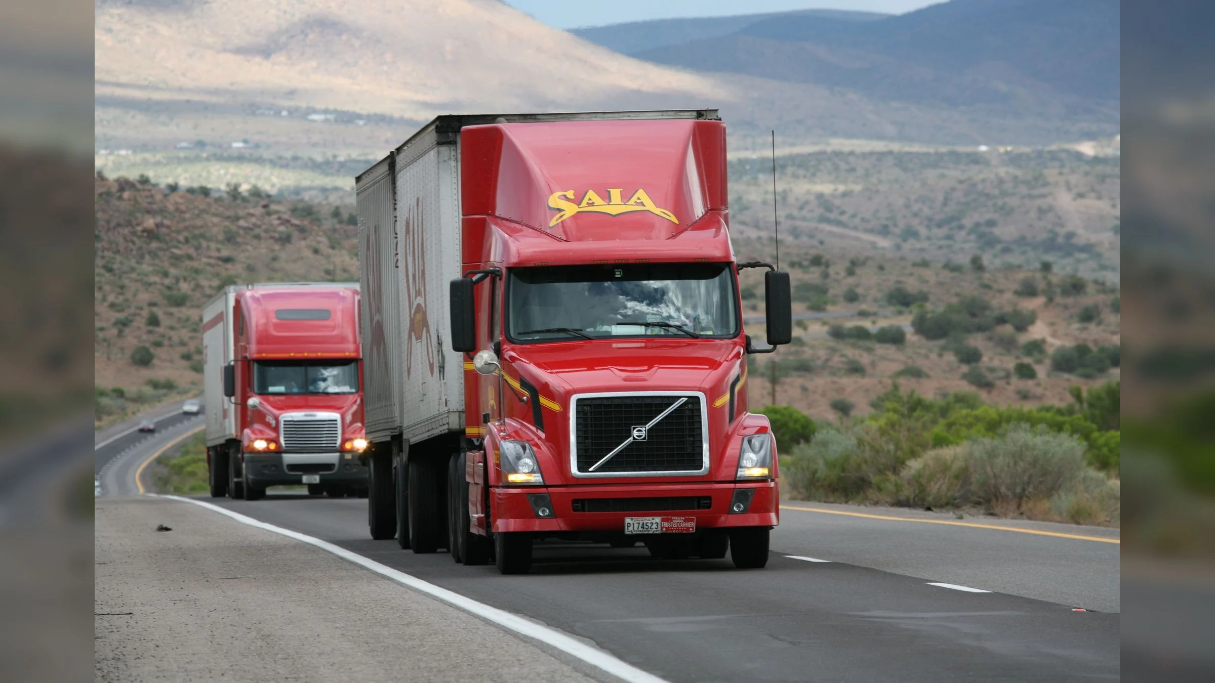 Aerial view of freight trucks moving along a major highway corridor